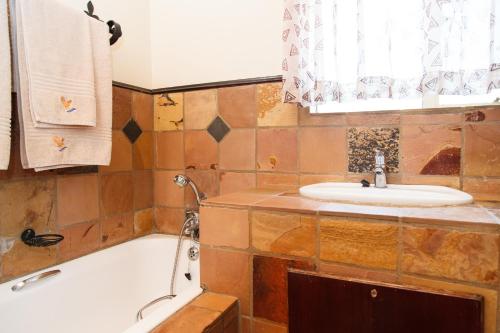 a bathroom with a sink and a bath tub at Blyde Canyon, A Forever Resort in Matibidi