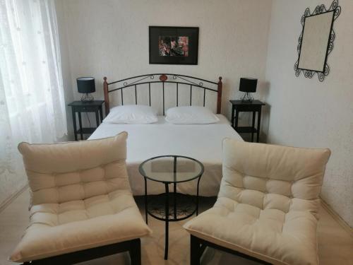 a bedroom with a bed with two chairs and a table at Apartment Paris with jacuzzi and sea view in Šmrika