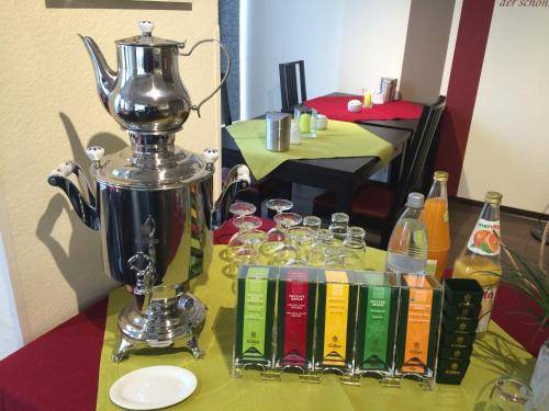 a table with a blender and wine glasses on it at Hotel Garni am Goetheplatz in Bad Münster am Stein-Ebernburg