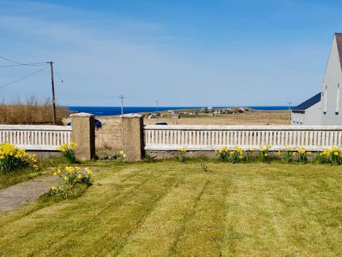 a yard with a white fence and a white church at Bayview in Bragor