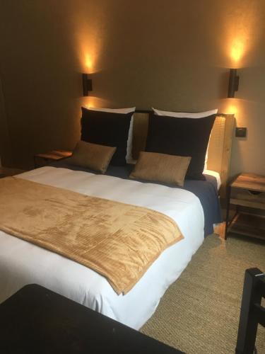 Cette chambre comprend un grand lit et 2 lampes. dans l'établissement Les Remparts, à Châteauneuf-du-Faou