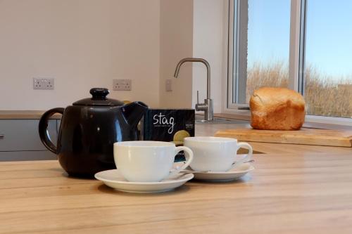 two coffee cups and a tea kettle on a kitchen counter at Bayview in Bragor