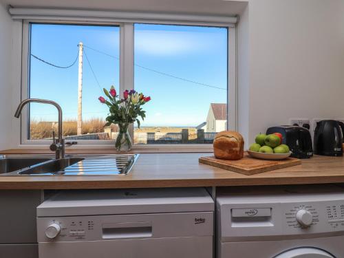 a kitchen with a counter with a window and a sink at Bayview in Bragor