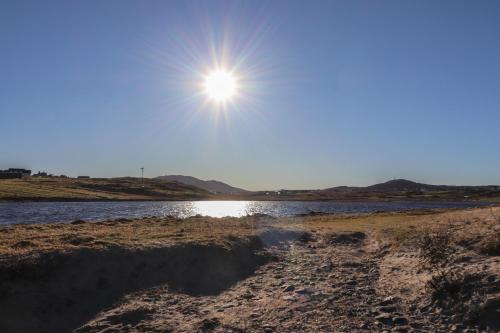a sun shining in the sky over a body of water at Bayview in Bragor