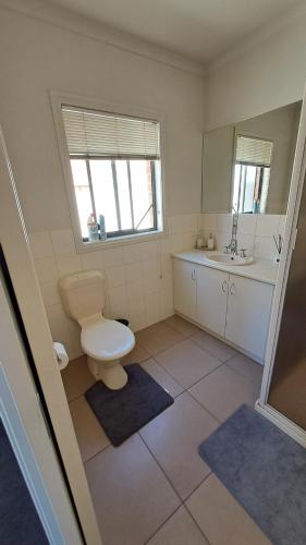 a bathroom with a toilet and a sink at Cozy comfortable House in Mildura