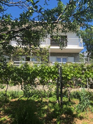 a white building in front of a building at Apartment Paris with jacuzzi and sea view in Šmrika