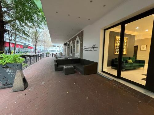 a lobby with couches and tables in a building at Near CTICC Professional & Cosy Hotel Room in Cape Town