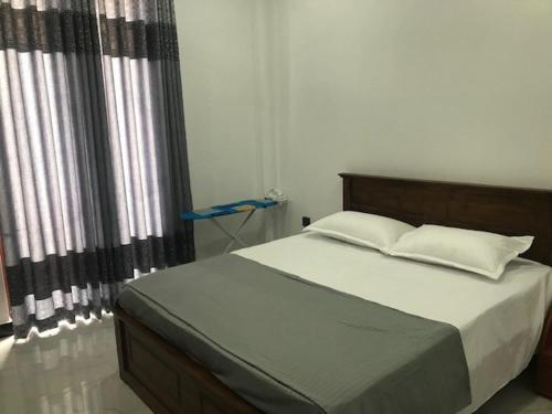 a bedroom with a large bed with white sheets and pillows at Three Bedroom Apartment in Kiribathgoda