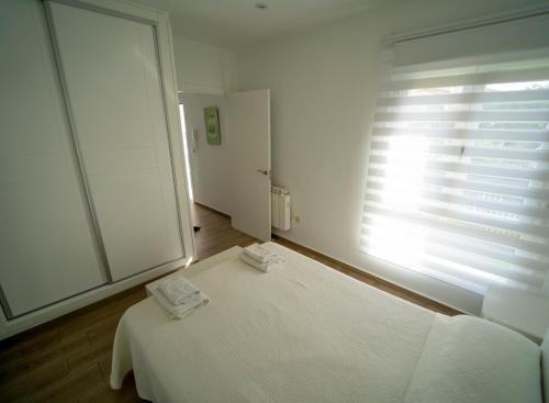 a white room with a bed and a window at Apartamento San Miguel Nº1 in Jarandilla de la Vera