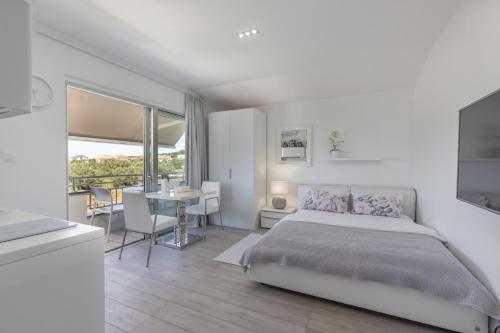 a bedroom with a bed and a dining room with a table at Villa Lalic Gallery - Adriatic Luxury Villas in Bibinje