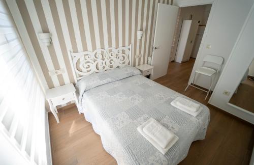 a bedroom with a white bed and two white chairs at APARTAMENTO SAN MIGUEL N.2 in Jarandilla de la Vera