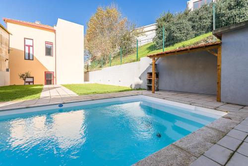 a swimming pool in the backyard of a house at GuestReady - Easygoing Pool to River in Vila Nova de Gaia