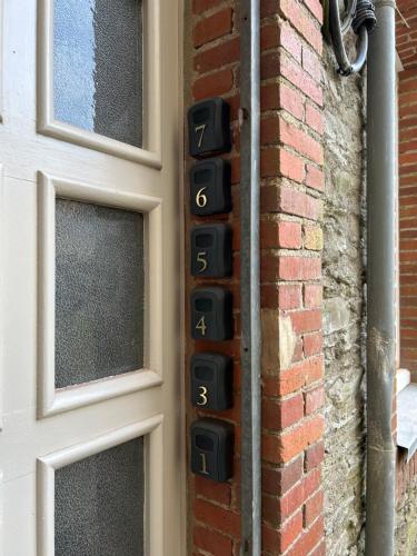 a door with numbers on it next to a brick wall at L'authentique - Appartement 4 in Loudéac