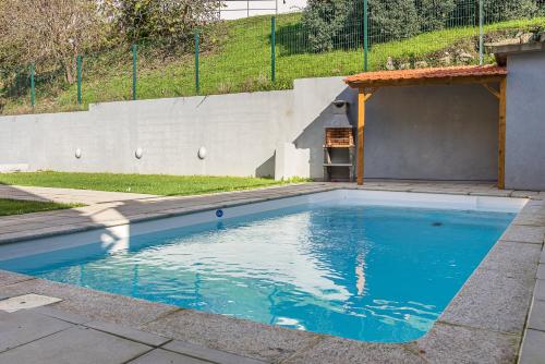 a swimming pool with blue water in a yard at GuestReady - Easygoing Pool to River in Vila Nova de Gaia
