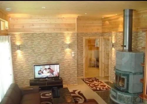a living room with a television and a fireplace at Villa Iltaranta - Cottage on the shore of Lake Saimaaa in Savonlinna