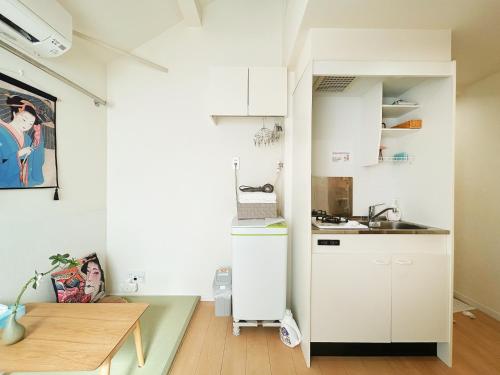 a small kitchen with white cabinets and a sink at Koenji loft apartment/Shinjuku&Kichijoji/JR in Tokyo
