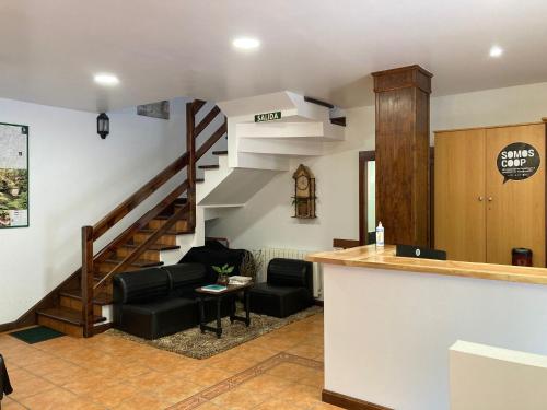 a living room with a spiral staircase and a couch at Albergue O Beque in Moaña