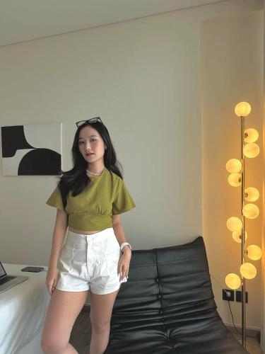 a woman is standing next to a bed at Apec Mandala Sea View Comhomes Phú Yên in Tuy Hoa