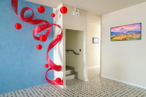 a room with a red spiral sculpture on the wall at Lá Riverside Boutique Hotel in Mỹ Phước