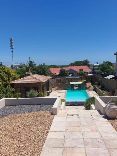a backyard with a swimming pool and a house at Ocean Glimpse in Cape Town