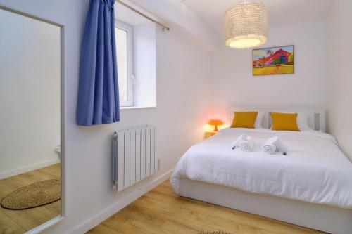 ヴィエンヌにあるLe Marty, T2 inoubliable, confort et styleのベッドルーム(白いベッド1台、青いカーテン付)