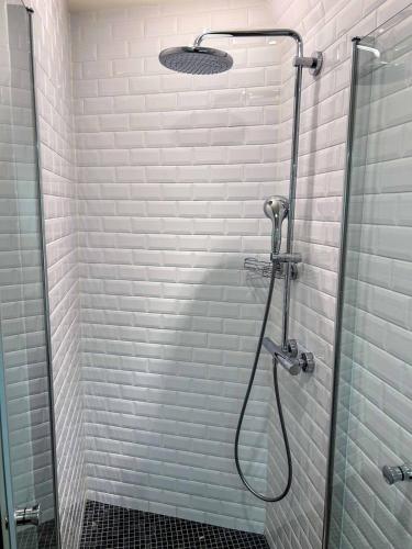 une salle de bain avec une douche avec une porte vitrée dans l'établissement Hideaway Retreat Eiffel Tower, à Paris