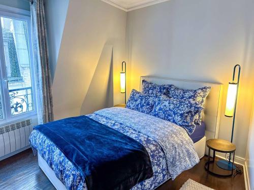 une chambre avec un lit avec des draps bleus et une fenêtre dans l'établissement Hideaway Retreat Eiffel Tower, à Paris