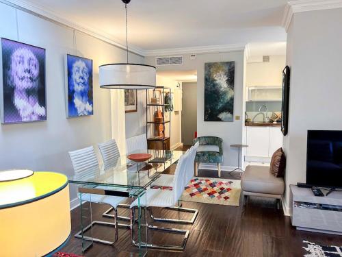 un salon avec une table en verre et des chaises dans l'établissement Hideaway Retreat Eiffel Tower, à Paris