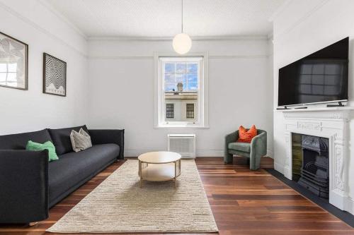 a living room with a couch and a fireplace at Perfect Vacation Home in Dawes Point in Sydney