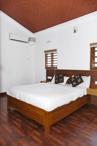 une chambre avec un grand lit dans une pièce dans l'établissement heritage inn, à Payyannūr