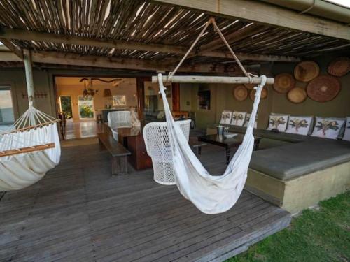 two hammocks hanging from a porch of a house at Highrocks Beach House in Umkomaas