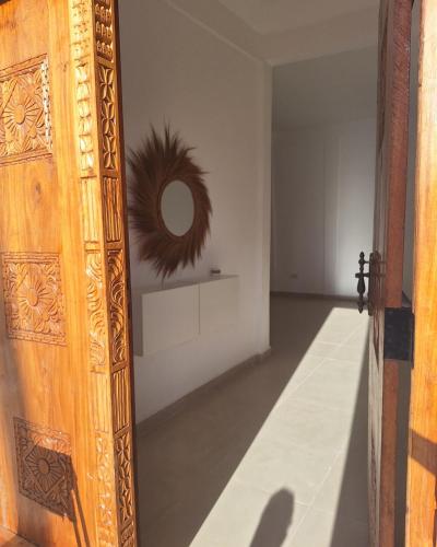 an open door to a room with a mirror at Private room in Villa Nali in Jambiani