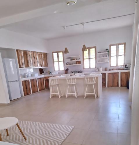 a large kitchen with white appliances and wooden cabinets at Private room in Villa Nali in Jambiani