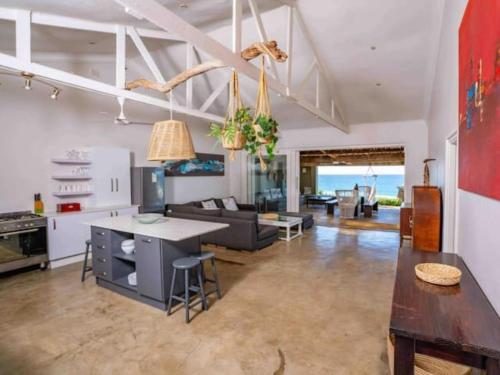 a kitchen and living room with a couch and a table at Highrocks Beach House in Umkomaas