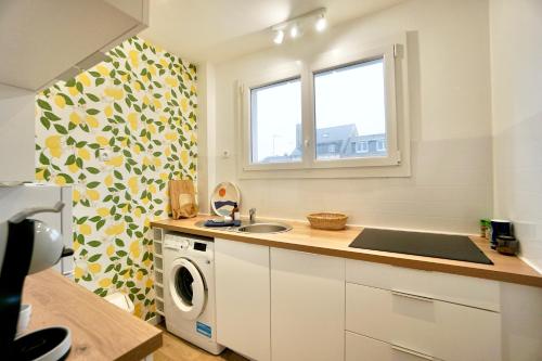 a kitchen with a sink and a washing machine at ty loulou - Hyper centre in Concarneau