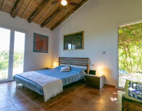 a bedroom with a bed with a blue comforter at Villa Clara in Tertenìa