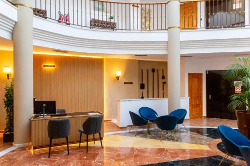 a lobby with chairs and a desk in a building at HOTEL HACIENDA SANTA BARBARA in Castilleja de la Cuesta
