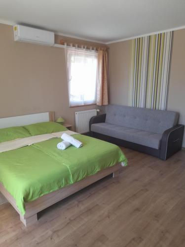 a bedroom with a bed and a couch at Berkes Vendégház in Badacsonytördemic
