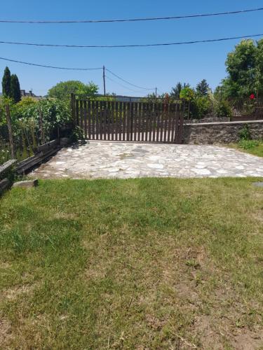 a yard with a wooden fence and grass at Berkes Vendégház in Badacsonytördemic