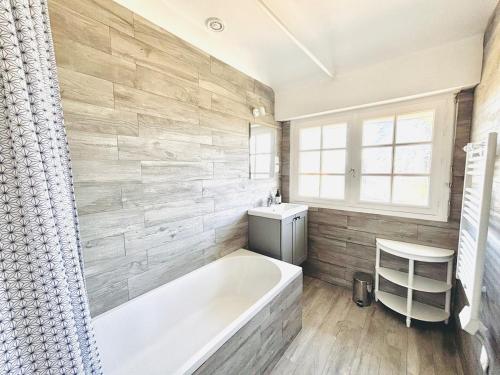 une salle de bain avec une baignoire et un lavabo dans l'établissement NOUVEAU! - maison a 500m de la plage, à Névez