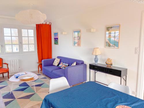 un salon avec un canapé bleu et une table dans l'établissement NOUVEAU! - maison a 500m de la plage, à Névez