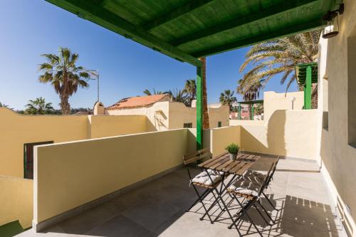 a patio with two chairs and a table on a building at Costa Calma Rio Barca Beach in Costa Calma