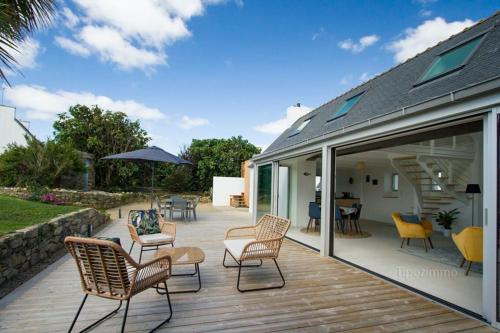 une terrasse avec des chaises et un parasol sur une maison dans l'établissement Tipoz'Immo-Ti Marin beach access - restaurants on foot - bed linen included, à Plovan