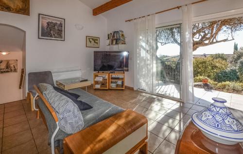 un salon avec un canapé et une télévision dans l'établissement Pet Friendly Home In Porto-Vecchio, à Porto-Vecchio