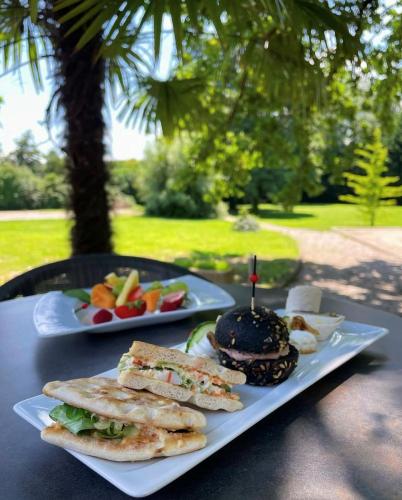 two plates with sandwiches and a hamburger on a table at Best Western Alexander Park Chambéry in Chambéry