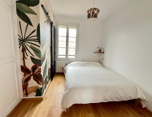 une chambre avec un lit blanc et une fenêtre dans l'établissement Charmant appartement Paris 12, à Paris