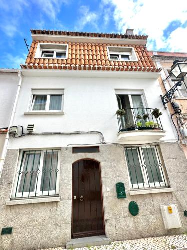 a white building with a door and two windows at Cascais Historic Villa in Cascais