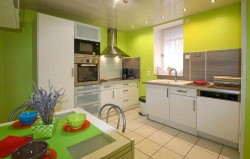 une cuisine avec des armoires blanches et des murs verts dans l'établissement 2 Bedroom Nice Home In Nyons, à Nyons