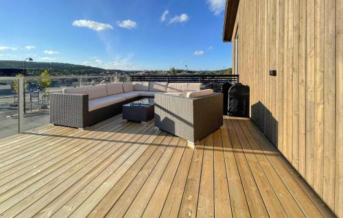 a deck with a couch and chairs on a building at 4 Bedroom Stunning Home In Søgne in Søgne