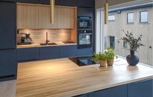 a kitchen with wooden cabinets and a wooden counter top at 4 Bedroom Stunning Home In Søgne in Søgne